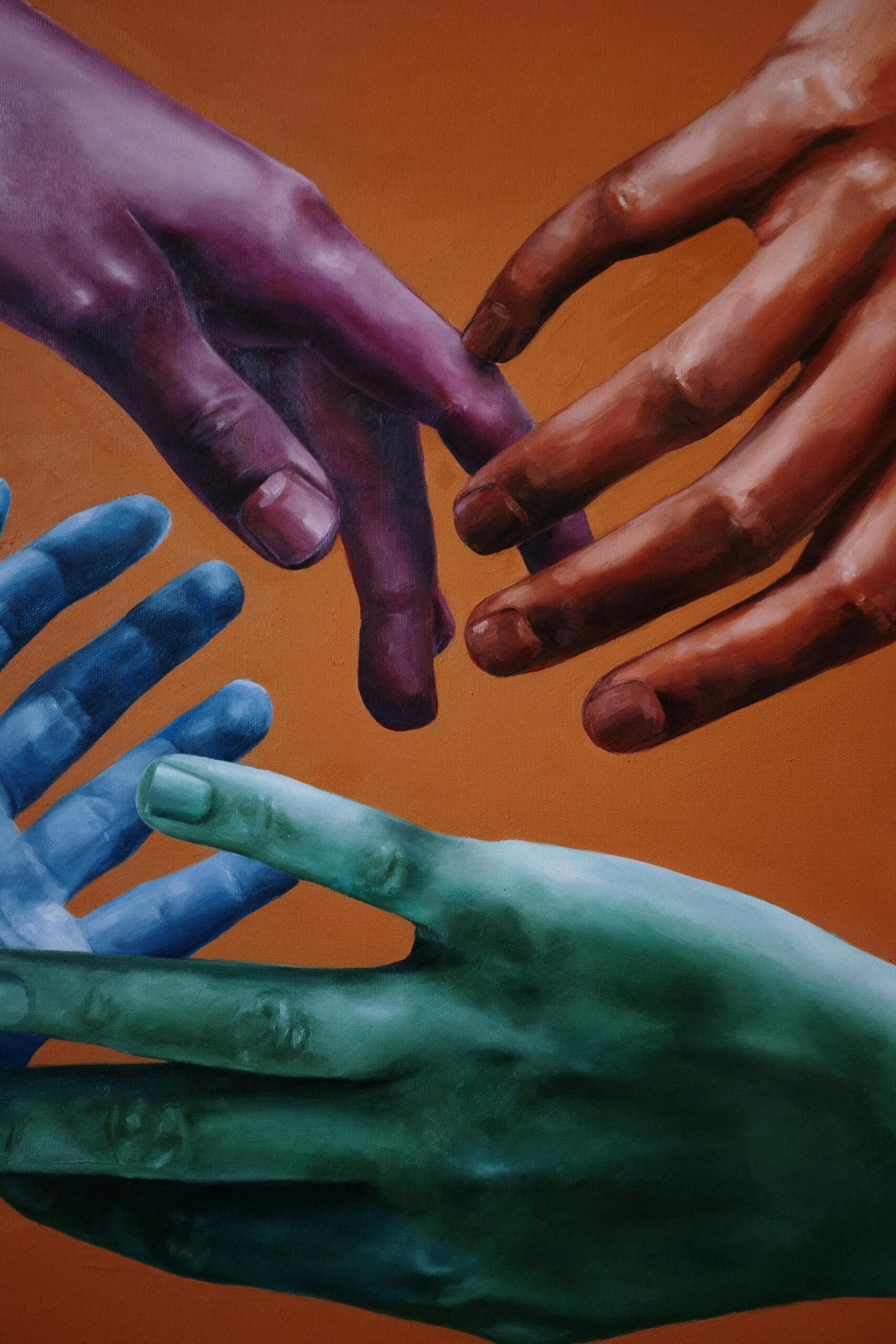 why-choose-us Artistic portrayal of multicolored hands on a vibrant orange background, symbolizing unity and diversity.